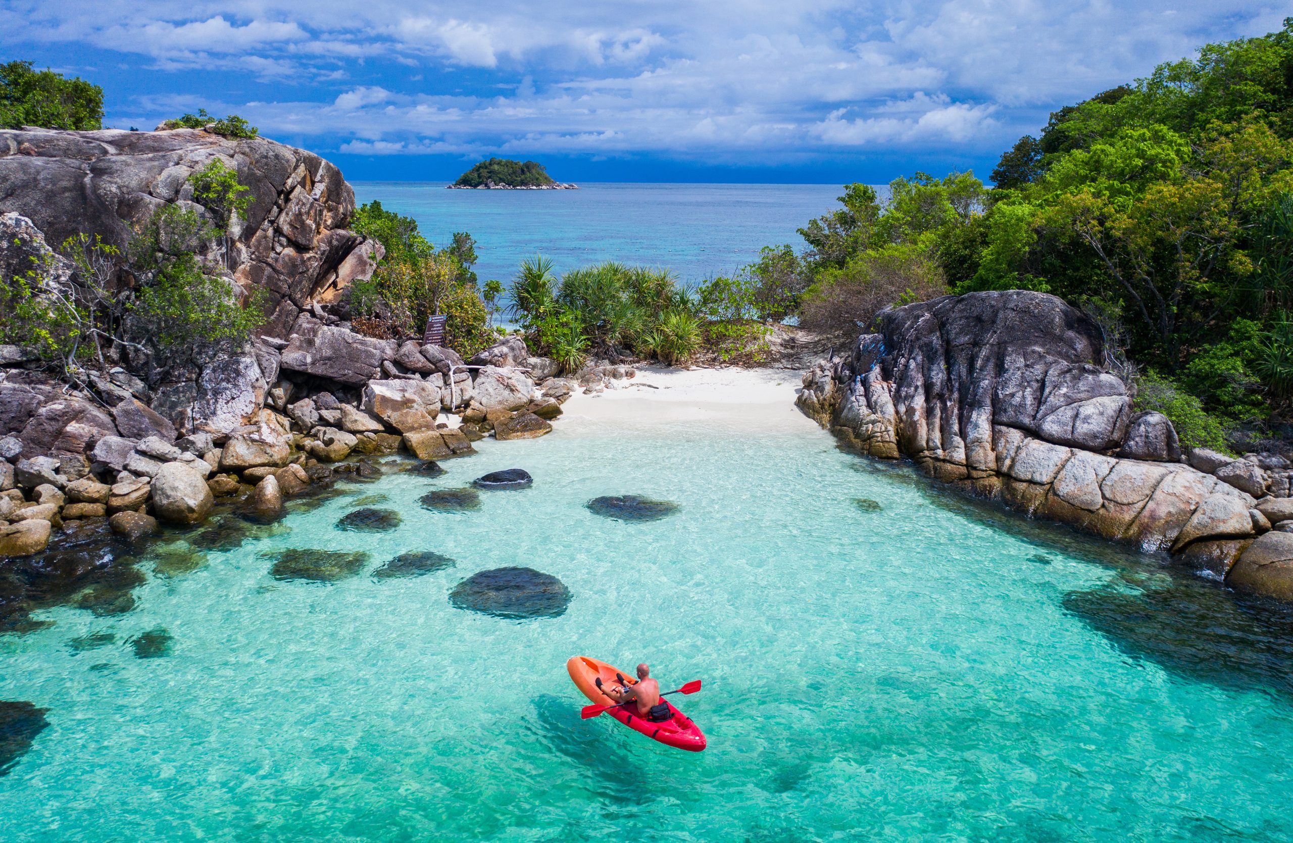 Kayaker in crystal clear water near Koh Lipe island in Thailand.